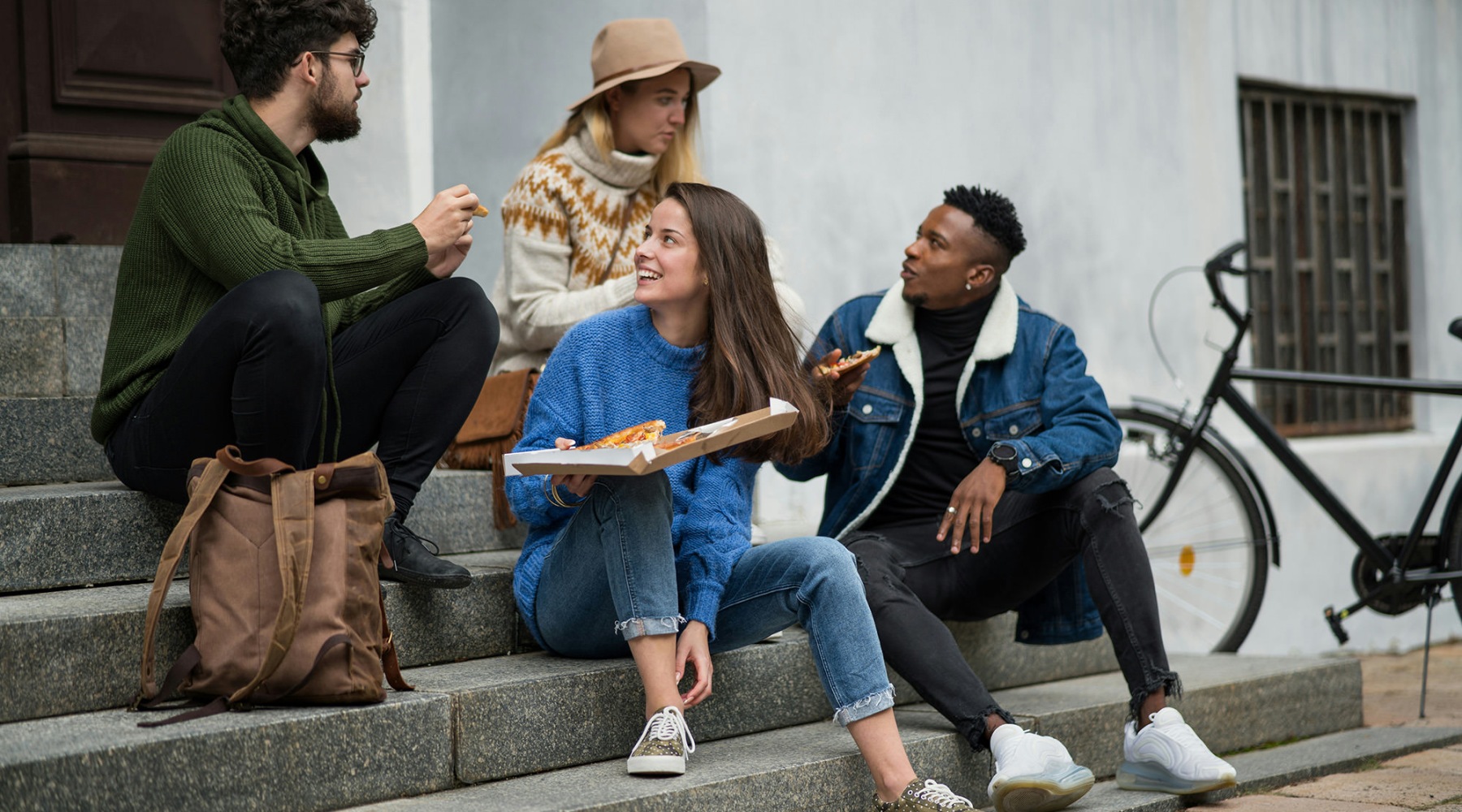 friends eating pizza outdoors